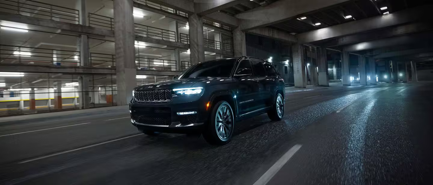 A black jeep grand cherokee drving on a road,