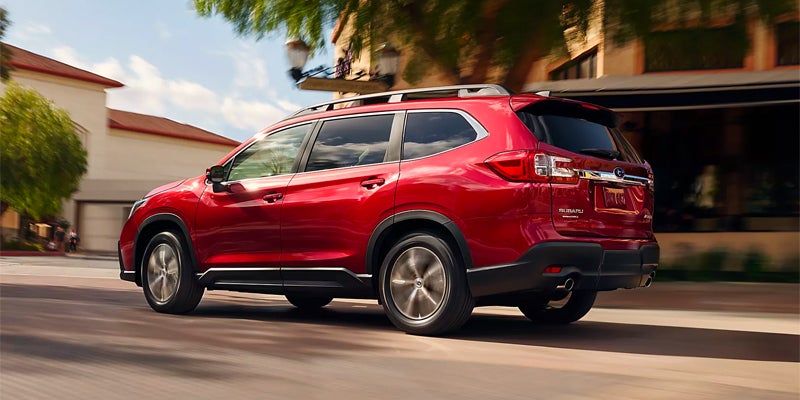 Red 2023 Subaru Ascent driving through a neighborhood