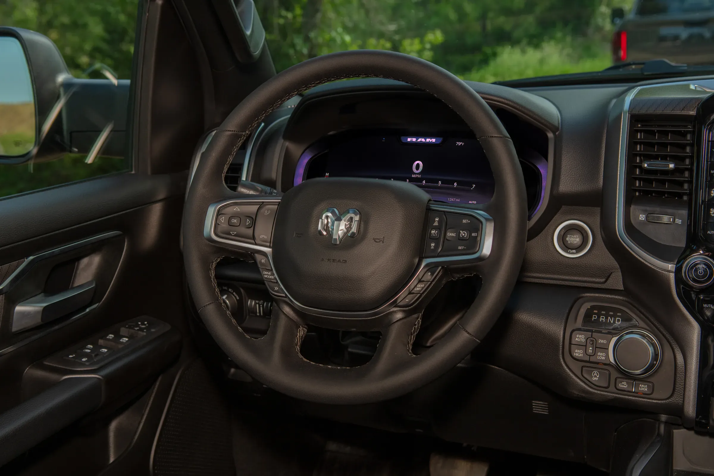 Interior close-up of a Ram truck's steering wheel featuring the Ram head logo, with the RAM-branded digital instrument cluster visible behind it. Starter Service Near Leavenworth, KS
