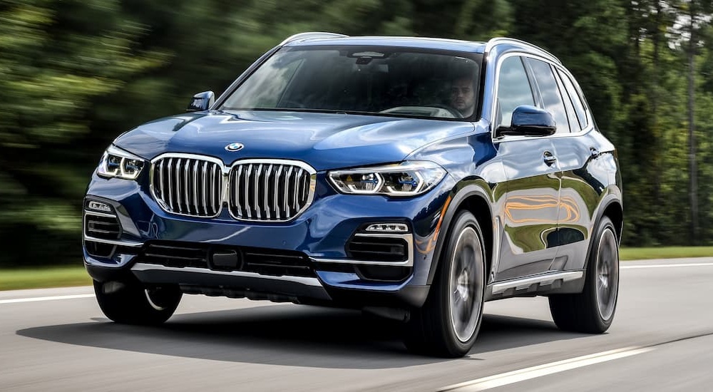 A blue 2019 BMW X5 driving on an open road.