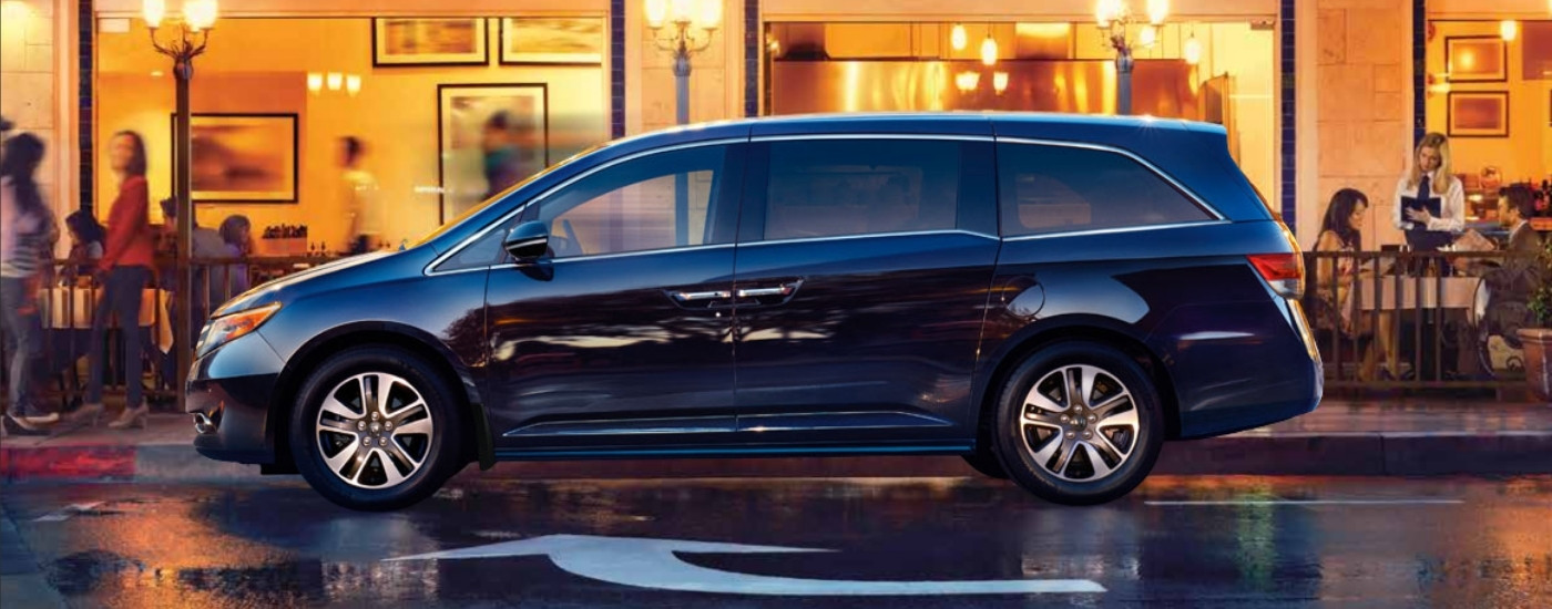 Blue 2014 Honda Odyssey parked in front of a restaurant 