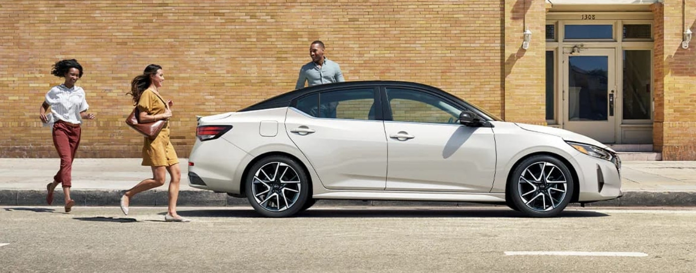 White 2025 Nissan Sentra parked in front of a brick building