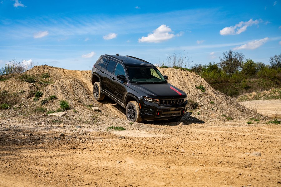 2027 Jeep Grand Cherokee Trailhawk Exterior Passenger Side Front Profile while Declining an Off-Road Hill