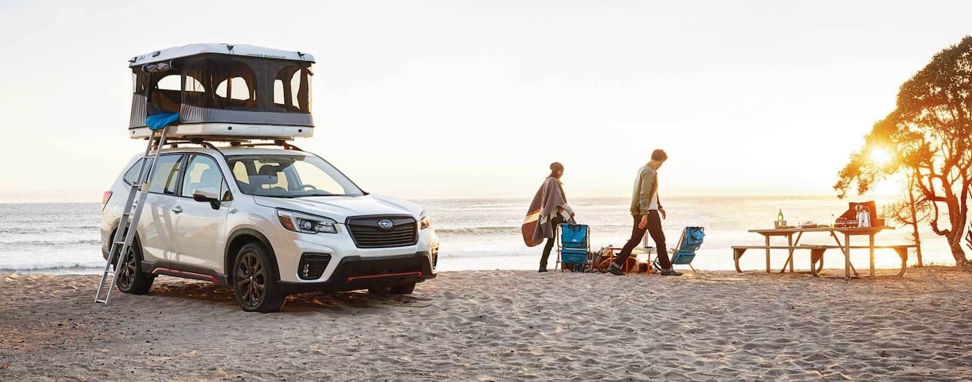 A white 2021 Subaru Forester with a tent on top.
