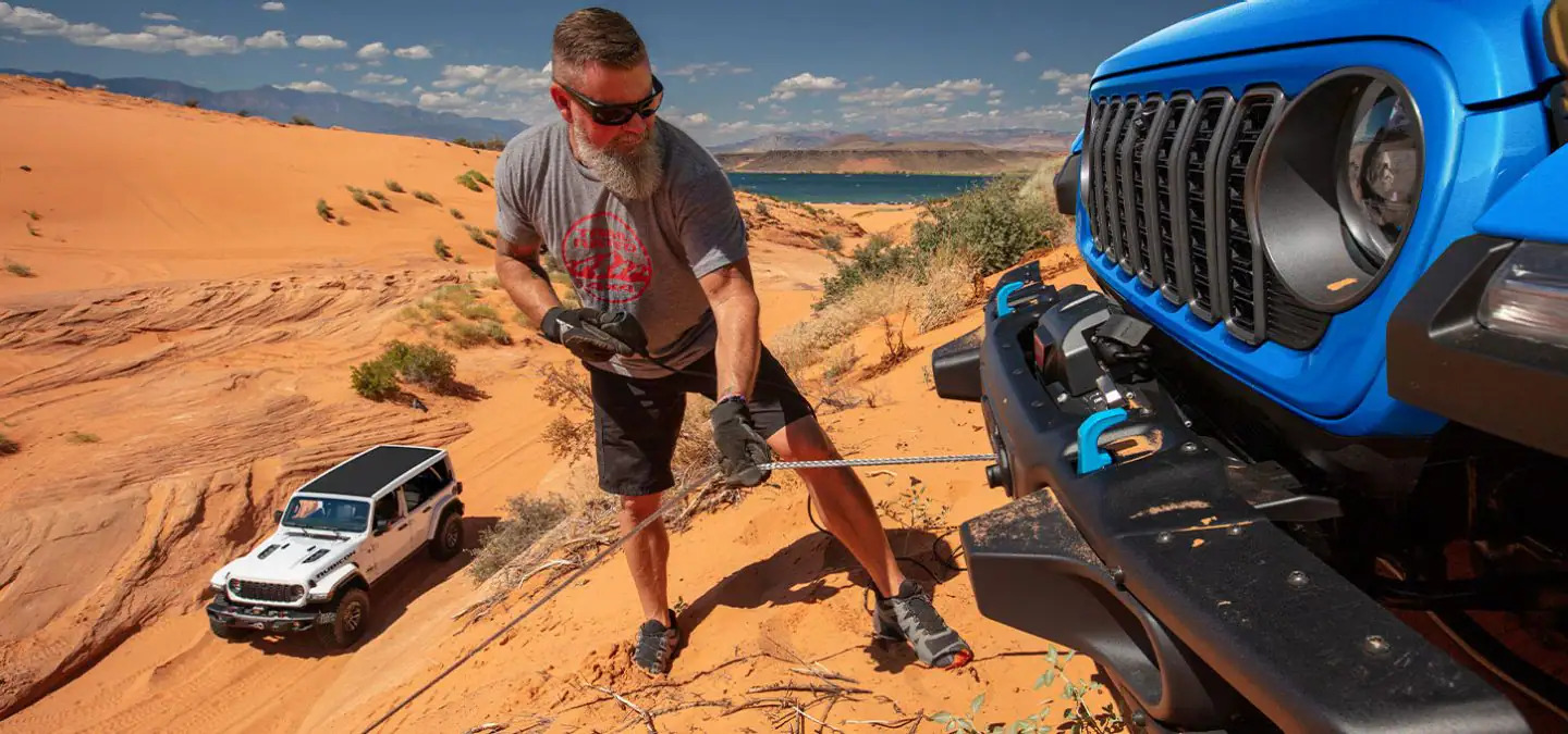 A man using the winch on a jeep.