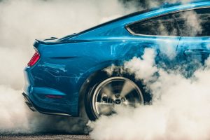 rear tire of a blue 2019 Ford Mustang doing a burn out