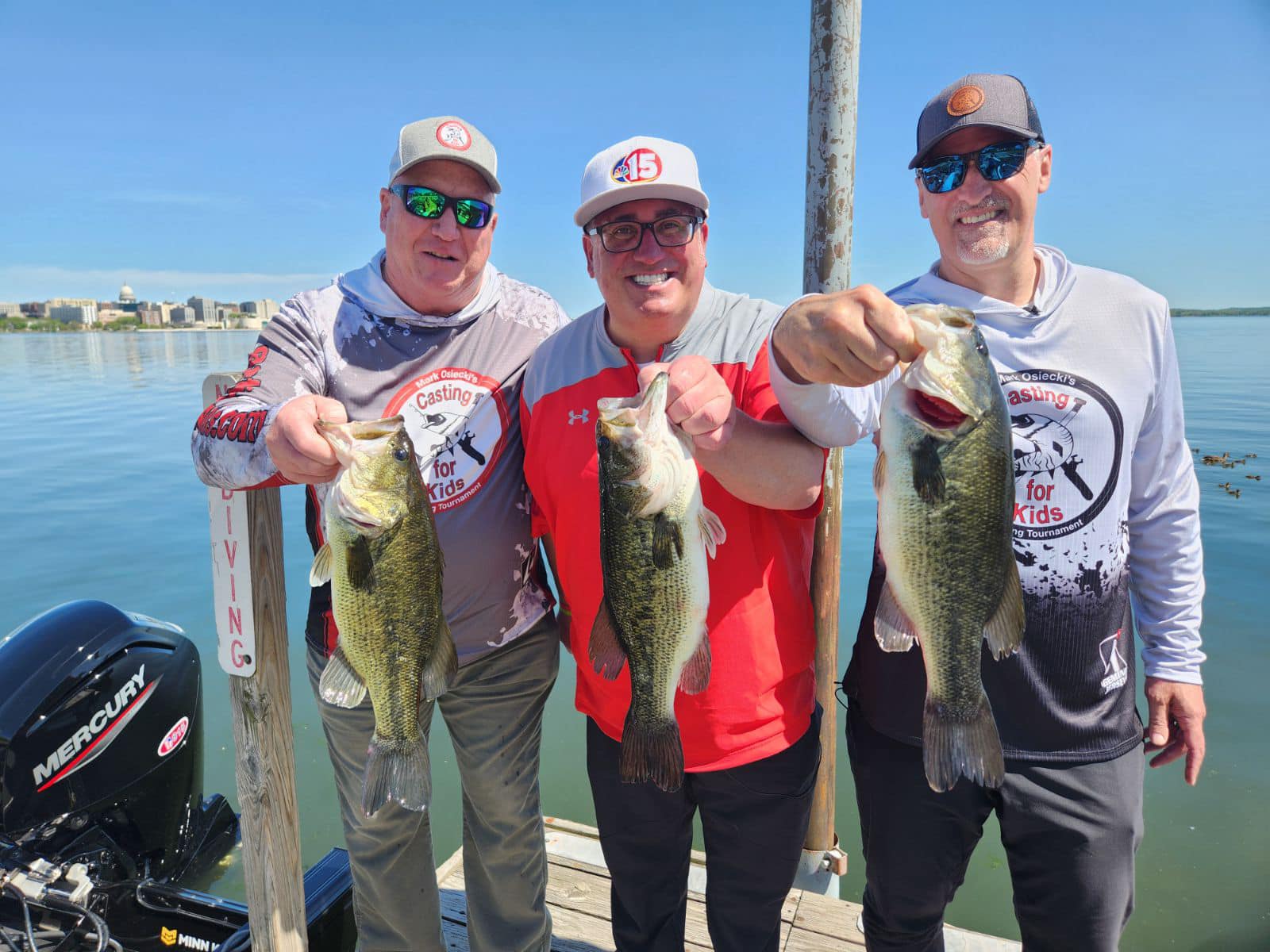 three participants proudly pose with the bass they caught at the Casting for Kids fishing tournament