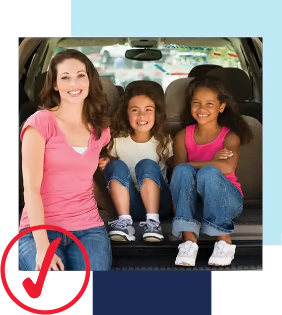 We're driving possibility. Mom in pink shirt and jeans with two daughters sitting in the back of a van or suv smiling at camera. Red icon in lower-left corner with check mark in circle.
