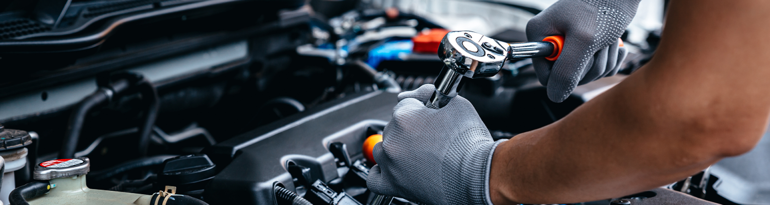 A service technician repairs a car engine.