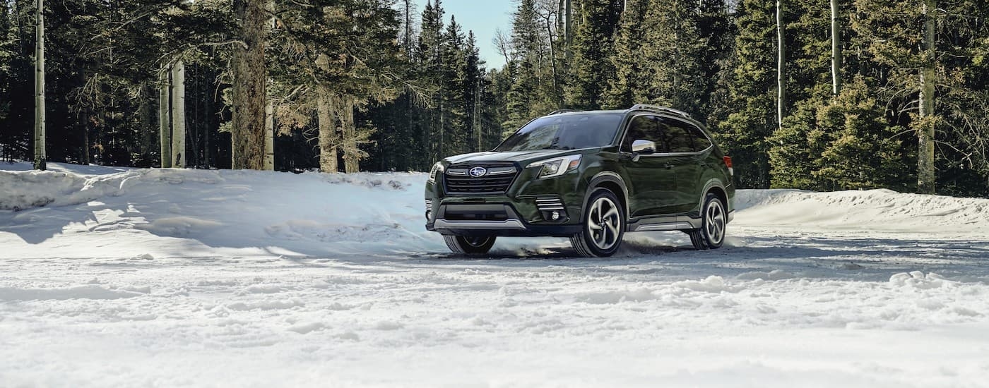 Green 2023 Subaru Forester parked on a snowy field