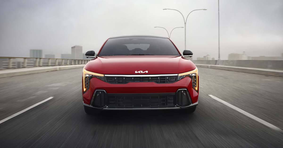 2026 Kia K4 driving down an open highway bridge