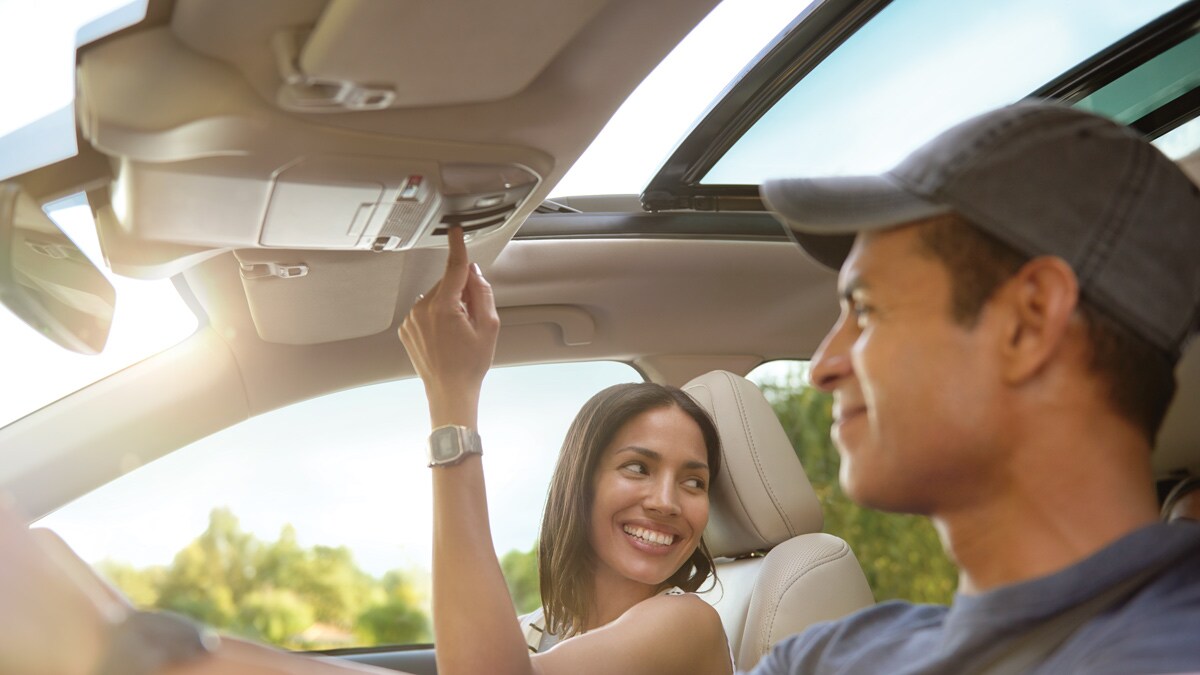 Hombre y mujer felices dentro de los asientos delanteros de un Subaru.