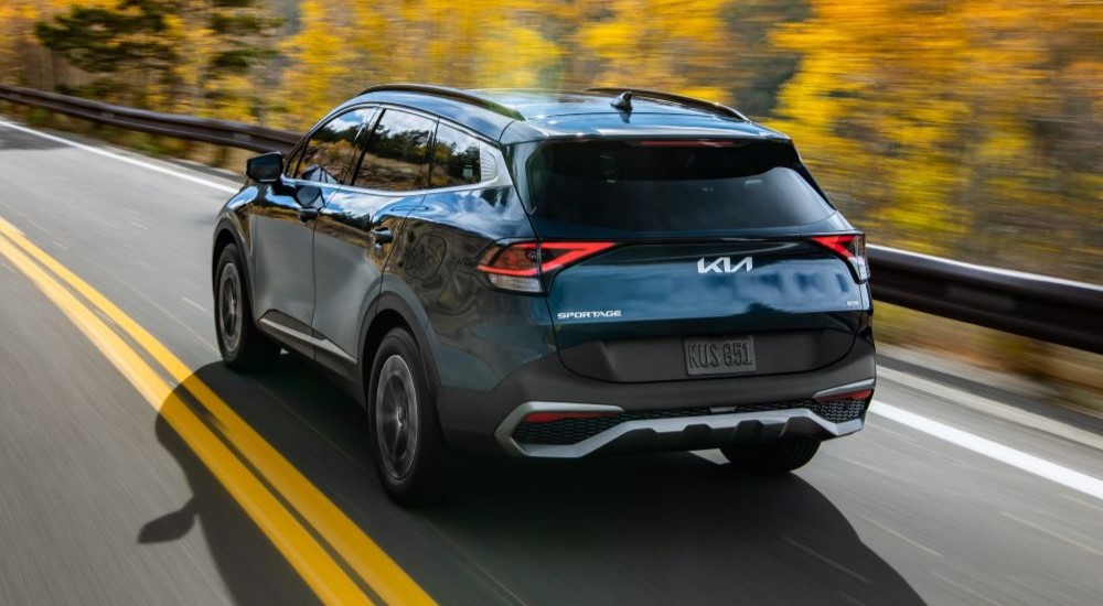 Blue 2023 Kia Sportage Hybrid driving on a highway