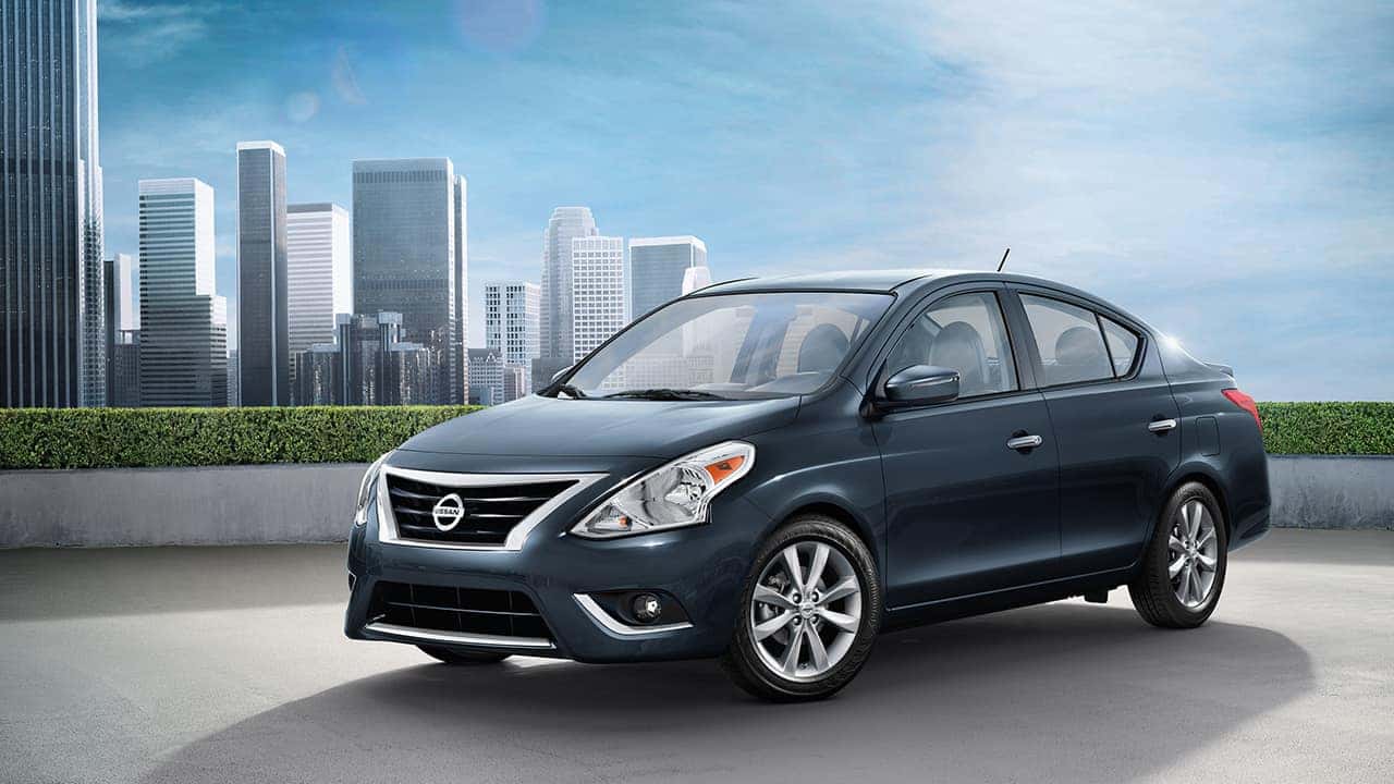 Dark blue 2017 Nissan Versa sedan in front of a city skyline