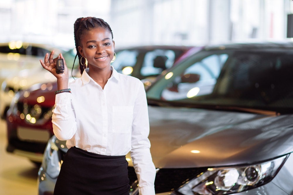 Smiling girl in a car dealership