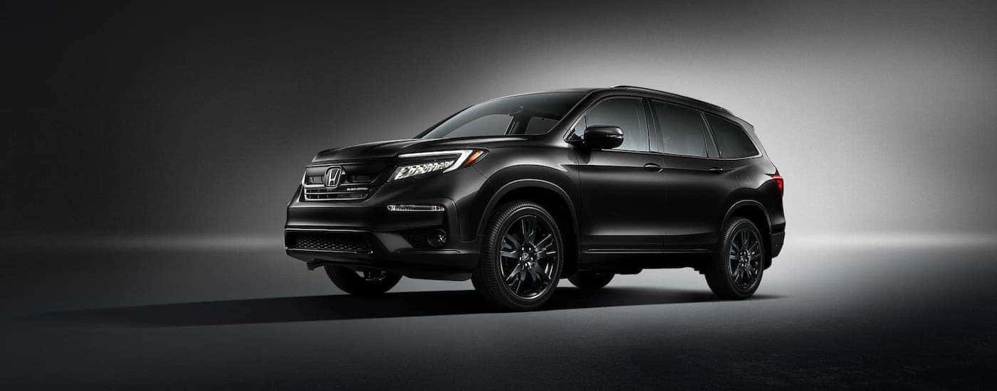 A black 2020 Honda Pilot on a black and white background.