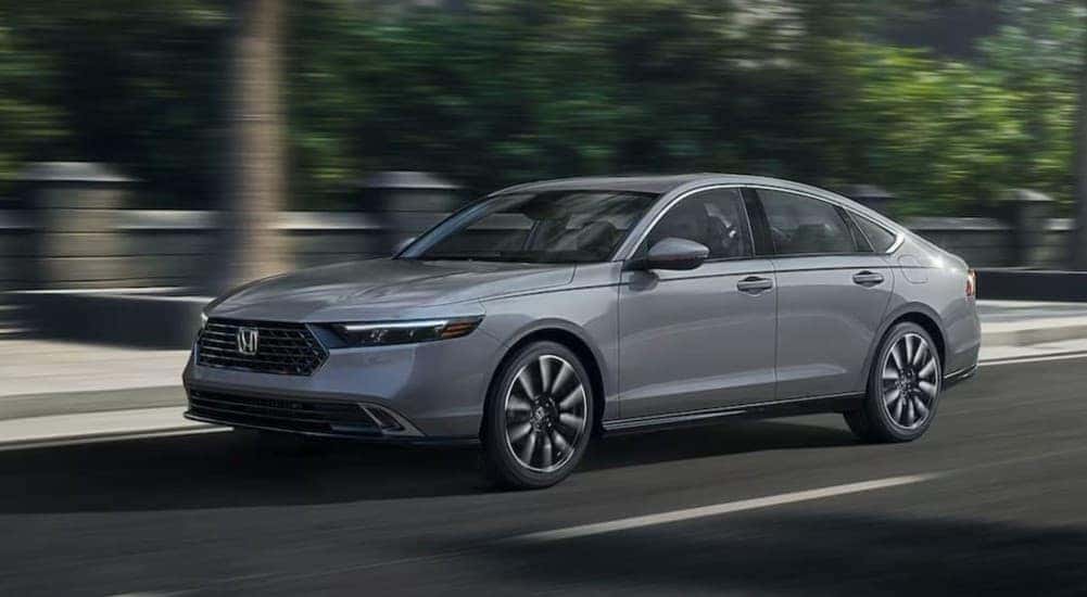 A silver 2025 Honda Accord driving in a city.