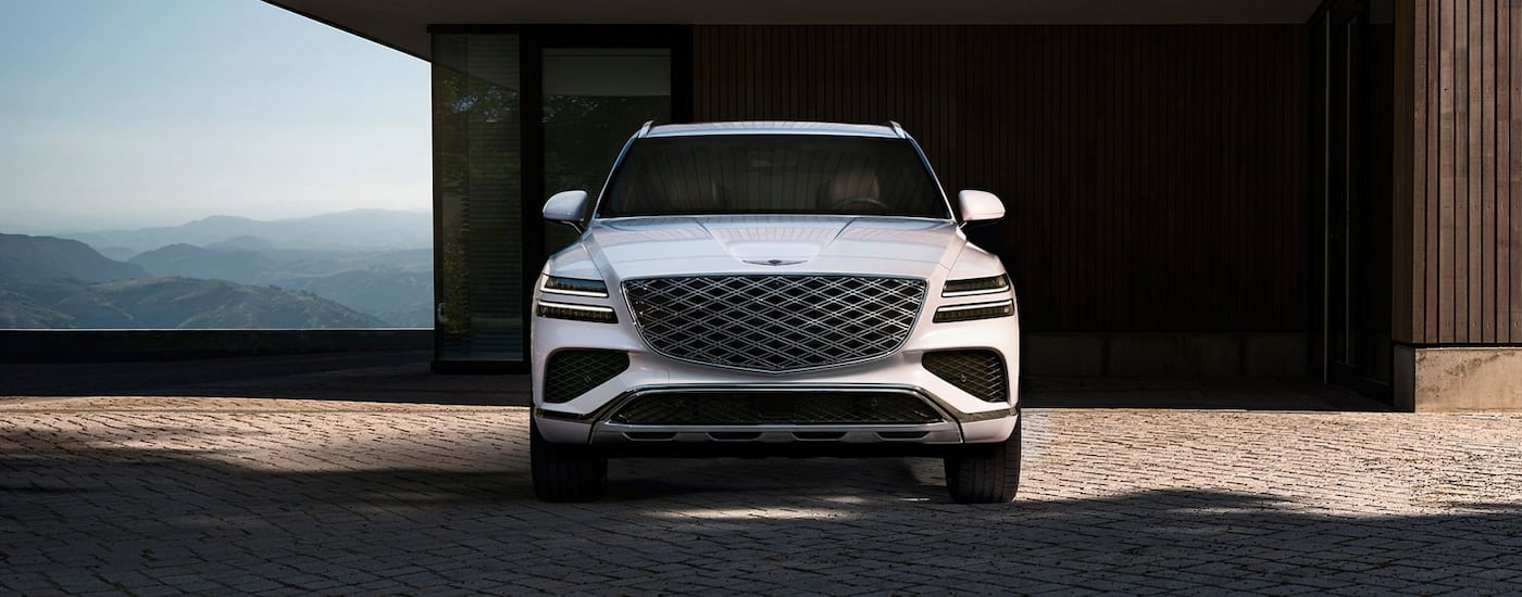 Front of a white 2025 Genesis GV80 parked outside a building.