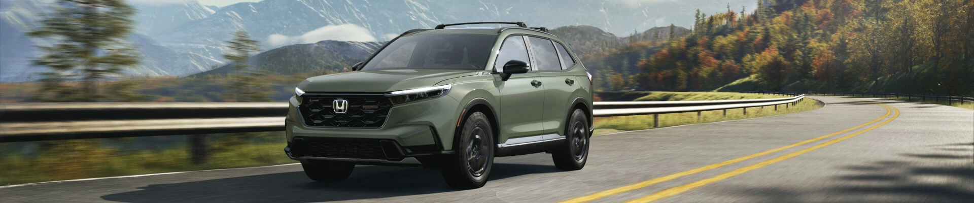 Front three-quarter view of a green Honda CR-V TrailSport Hybrid driving on a mountain road.   