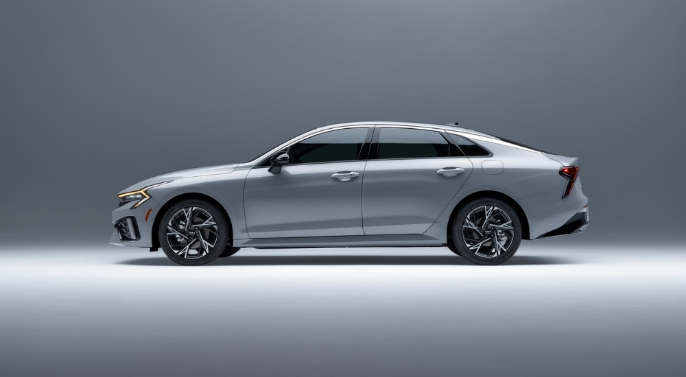 Silver 2025 Kia K5 for sale parked in a gallery