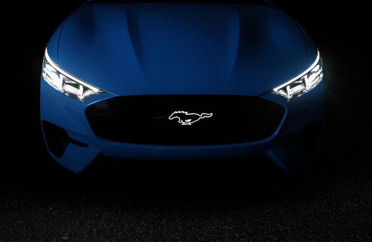 Blue 2024 Ford Mustang Mach-E in the Dark with Headlights and Logo Illuminated