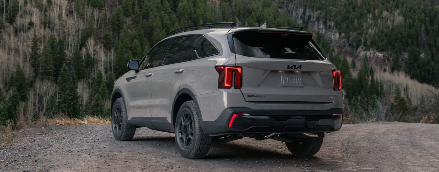 Rear view of a grey 2026 Kia Sorento parked off-road.