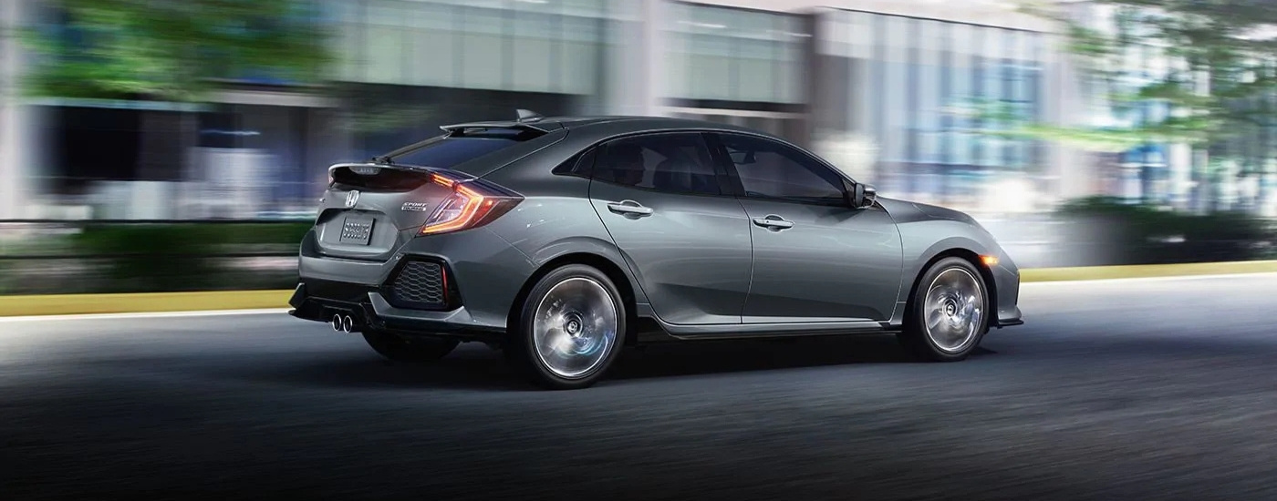 gray 2020 Honda Civic Hatchback Sport Touring driving on a city street