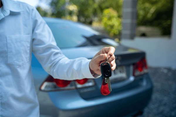 Person handing over the keys to a used car