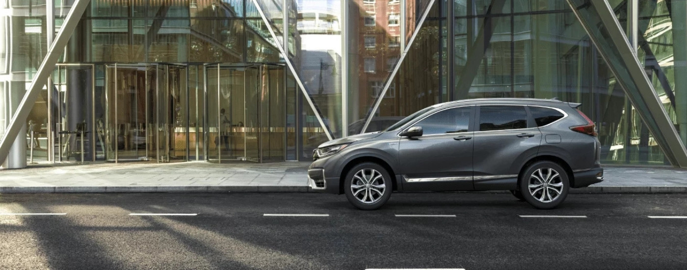 Grey 2022 Honda CR-V Hybrid Touring parked in front of a build