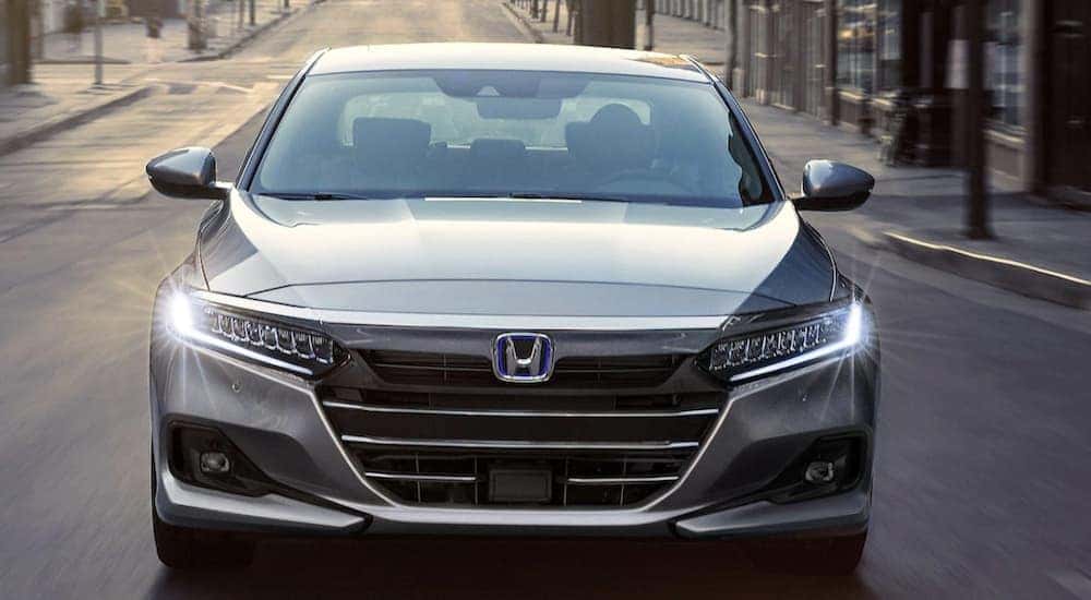 Grey 2022 Honda Accord Hybrid driving down a street.