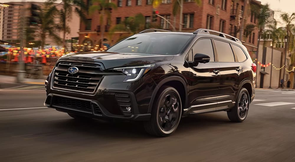 A black 2023 Subaru Ascent Onyx Edition driving on a city street.