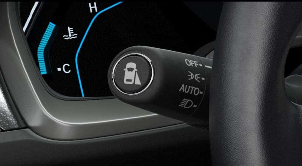 A close up is showing the lane assist icon on the headlight stalk of a 2021 Honda Civic.