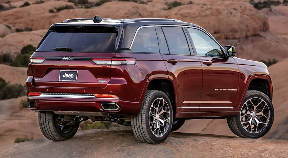 Rear view of a red 2023 Jeep Grand Cherokee parked off road.