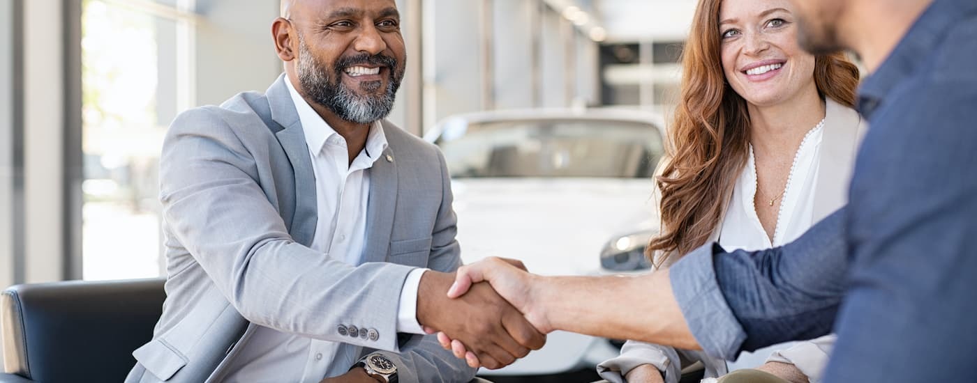 A sales person and customer shaking hands.