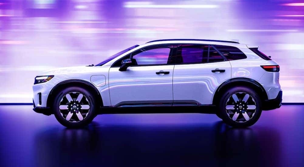 A white 2024 Honda Prologue is shown parked on a showroom floor.