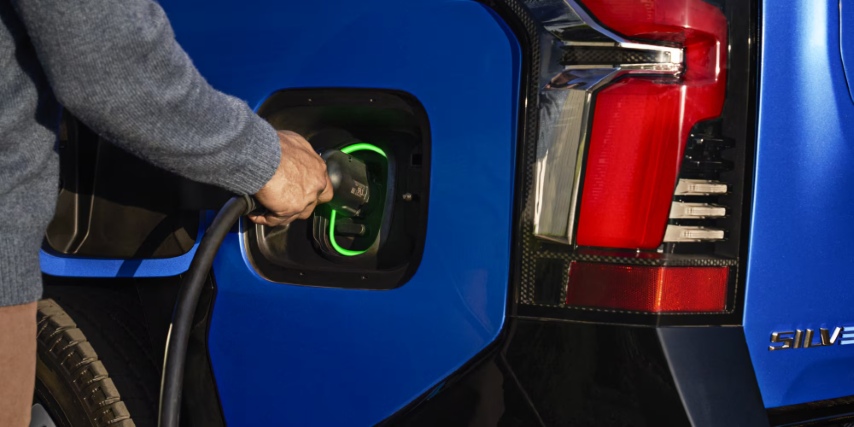 Person plugging charger into 2025 Silverado EV.