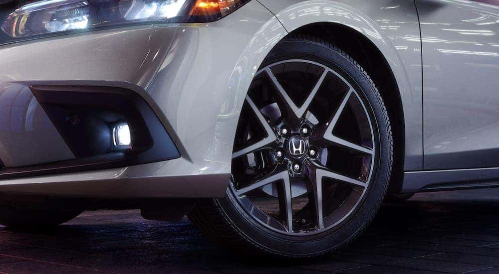 A close up of the wheel on a silver 2024 Honda Civic Hatchback Sport Touring.