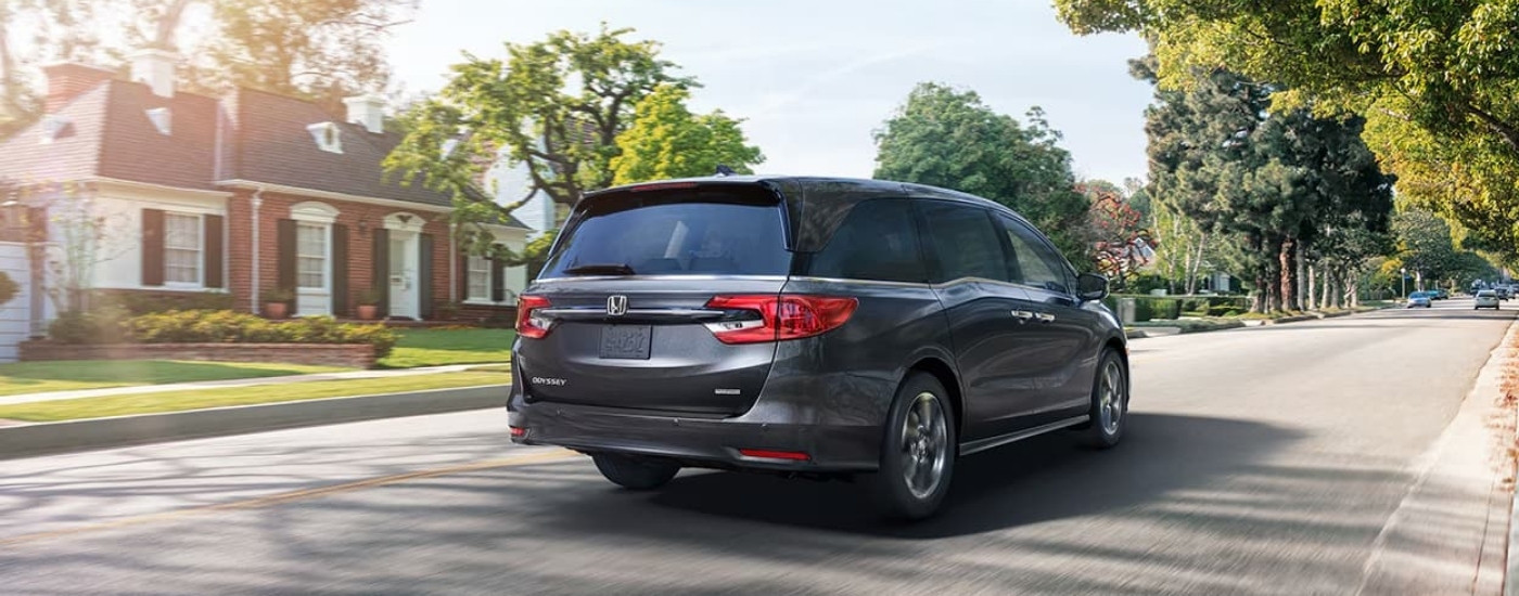 Grey 2021 Honda Odyssey driving on a suburban street