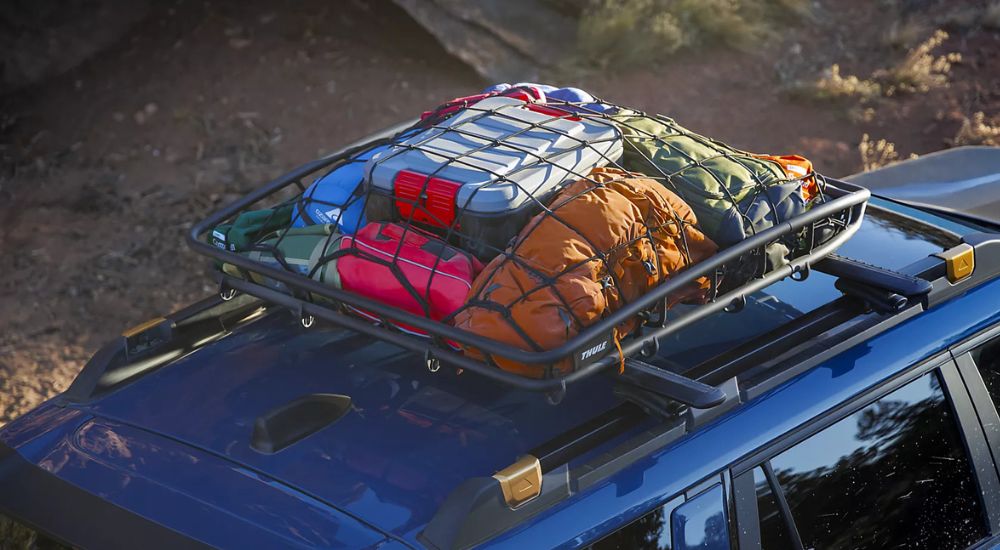 Roof rails with racking accessories on a blue 2027 Subaru Outback Wilderness.