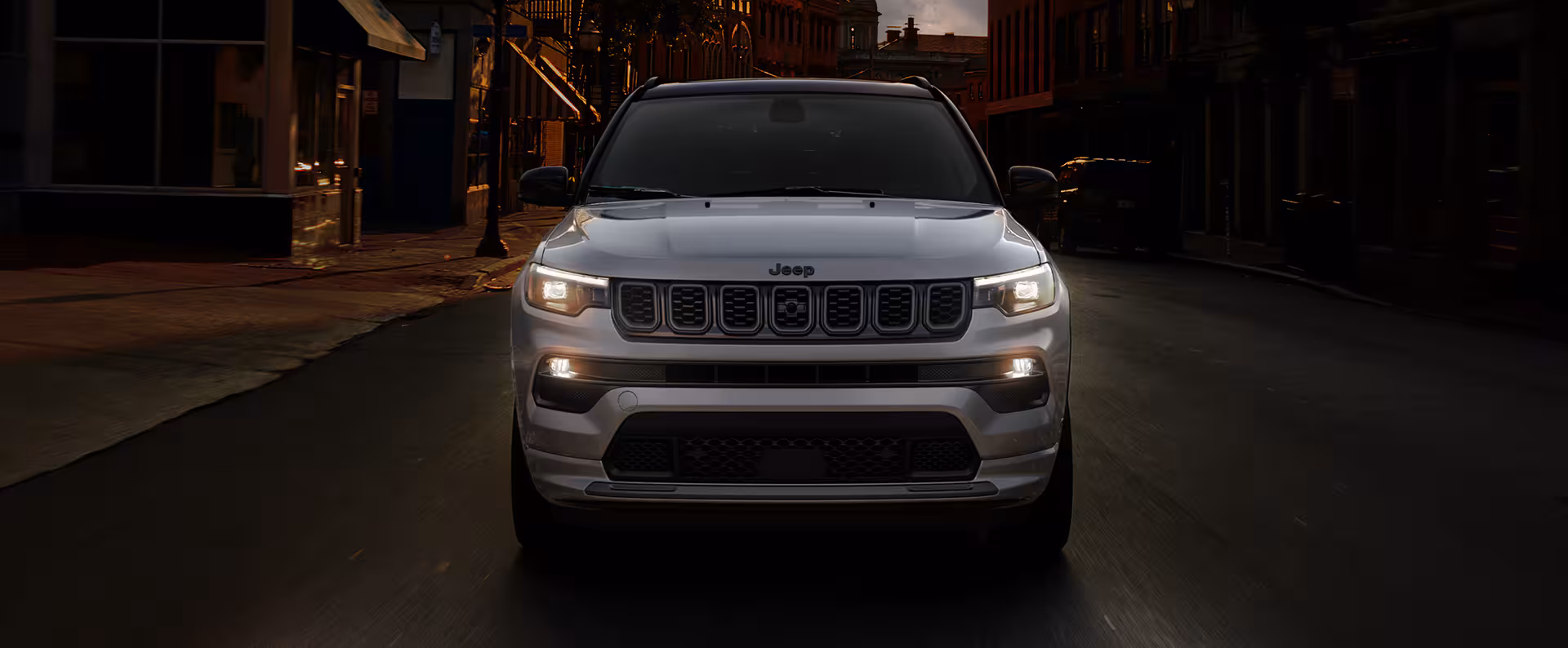 A silver suv driving on the road.