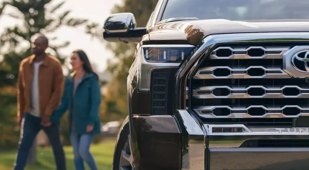 Couple walking near a brown 2022 Toyota Tundra 1794 CrewMax