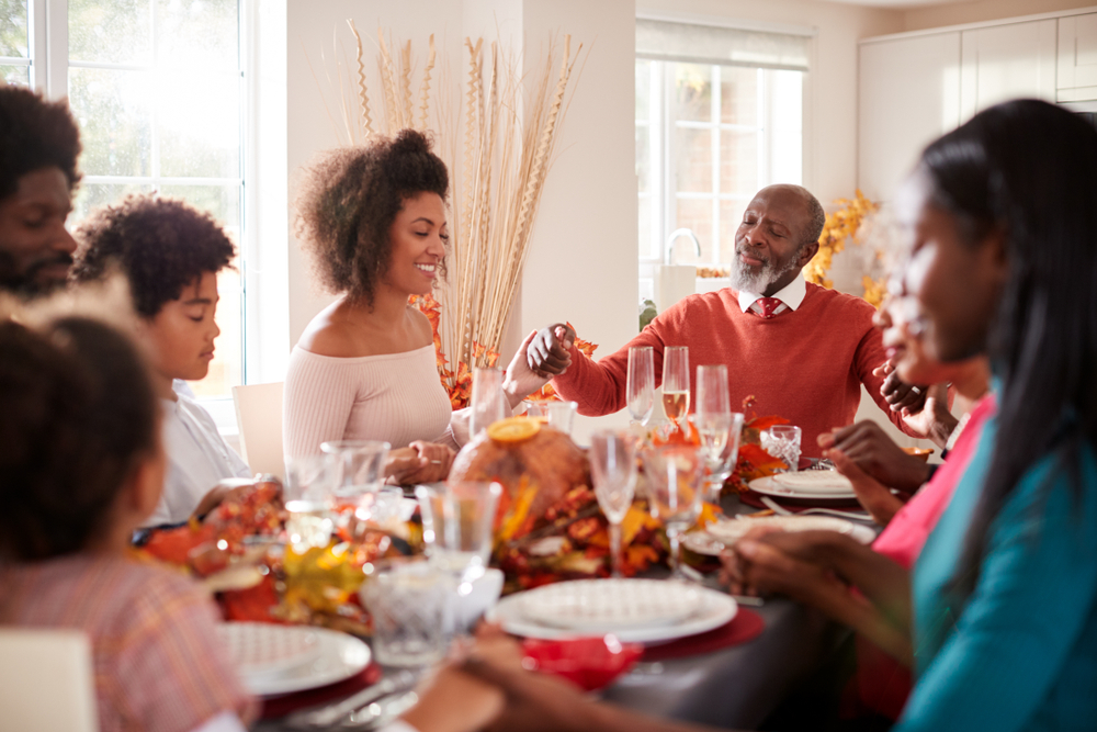 family prays before Thanksgiving meal