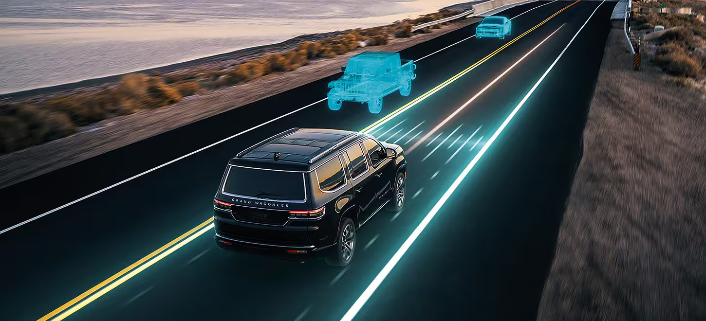 A black jeep wagoneer driving on a road.