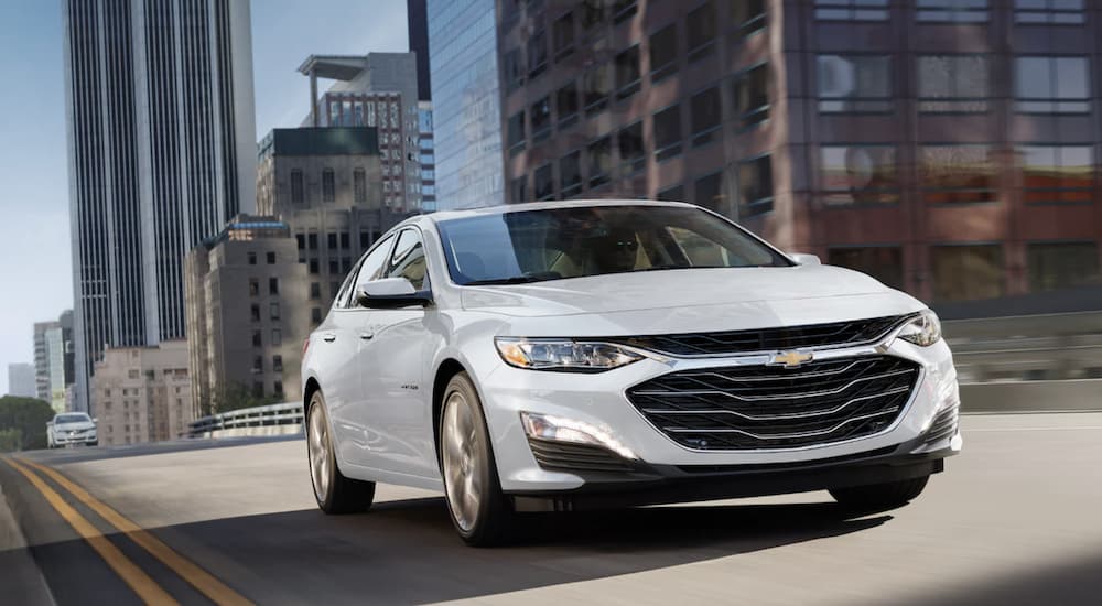 White 2022 used Chevy Malibu for sale driving on a city street