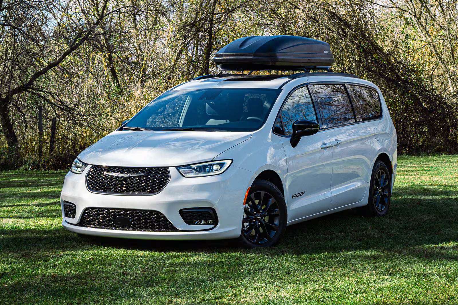 A white van sitting in the grass.