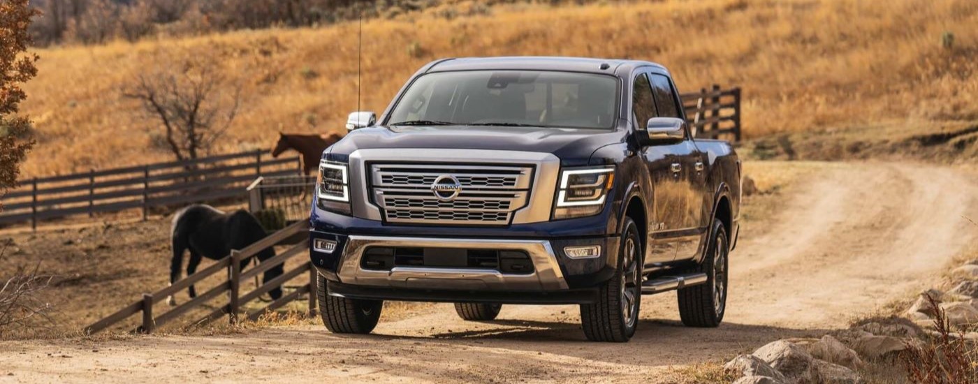 Black 2021 Nissan Titan parked near horses on a farm