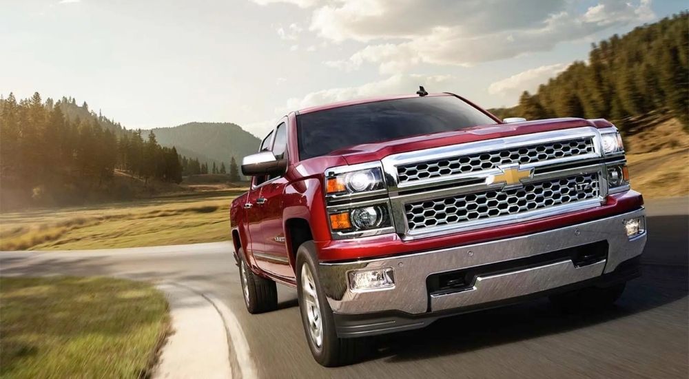 Red 2015 Chevy Silverado 1500 LTZ rounding a corner