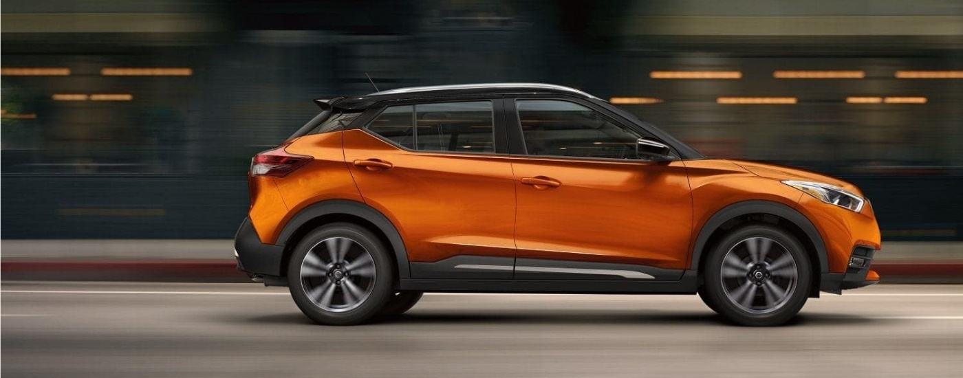 Orange 2018 Nissan Kicks for sale driving on a city street
