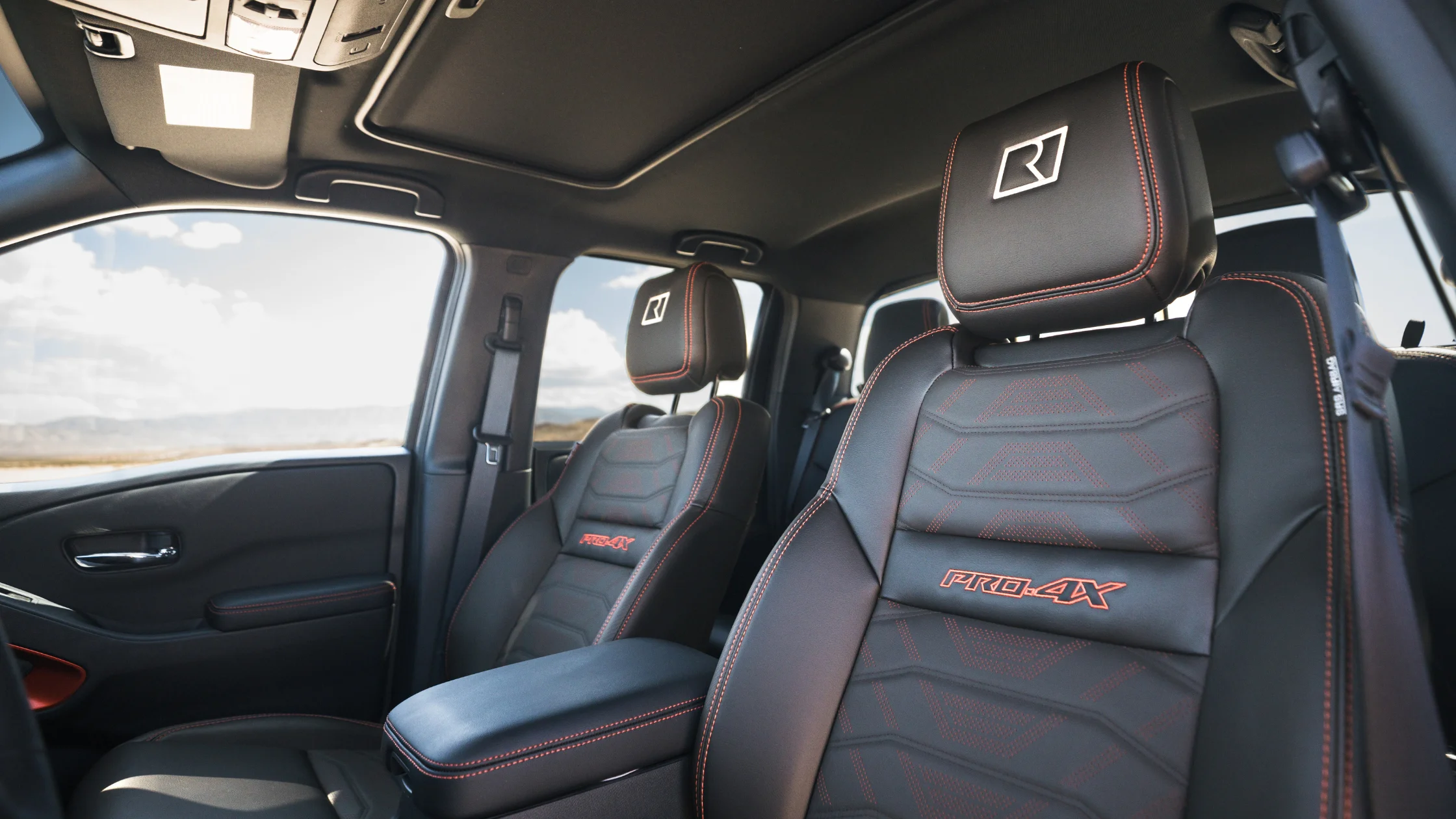 2026 Nissan Frontier® PRO-4X front seats with black leather, red stitching, and headrest logo