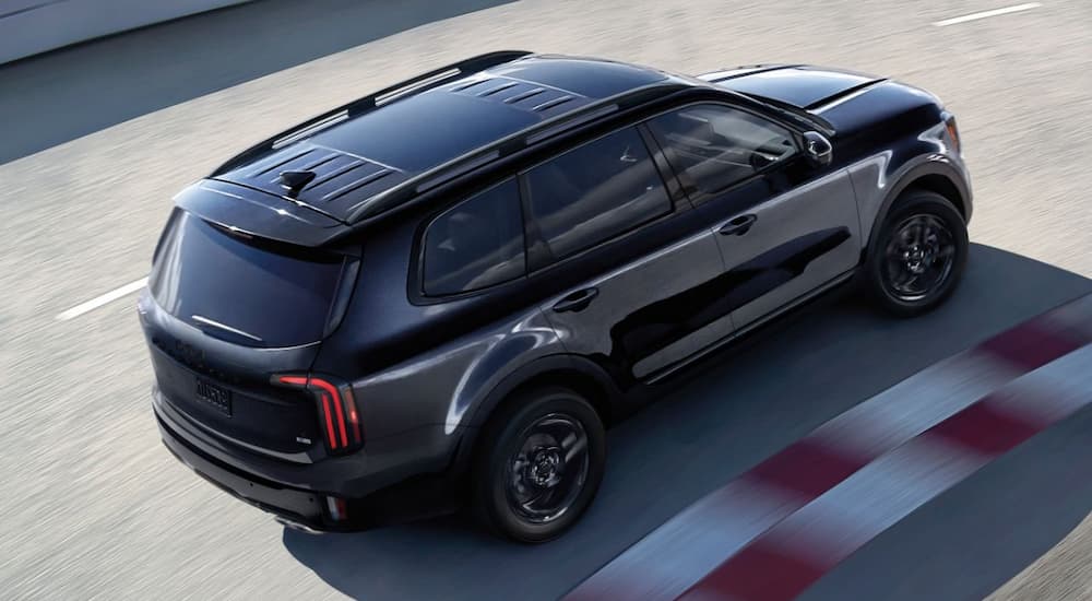 Black 2026 Kia Telluride driving down a track